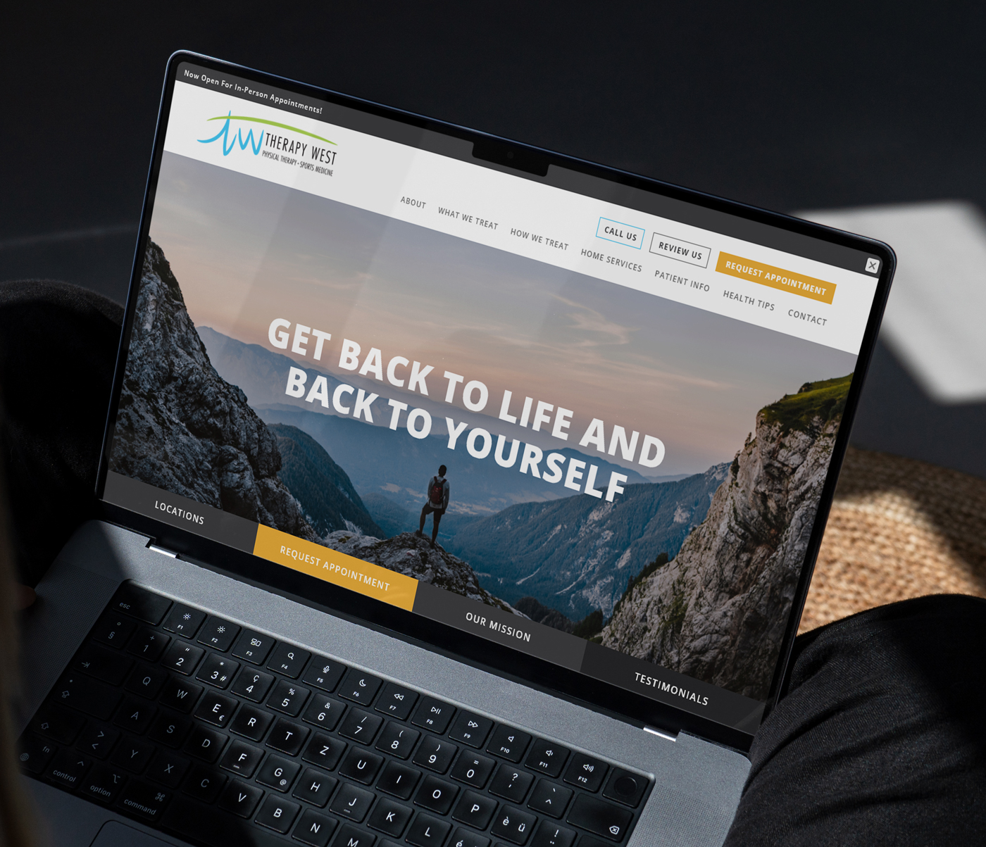 Laptop screen showing the homepage of Therapy West Physical Therapy. The page features a large hero image of a hiker standing on a mountain ridge with bold white text saying “Get Back to Life and Back to Yourself.” Navigation links and call-to-action buttons are visible at the top and bottom of the page.