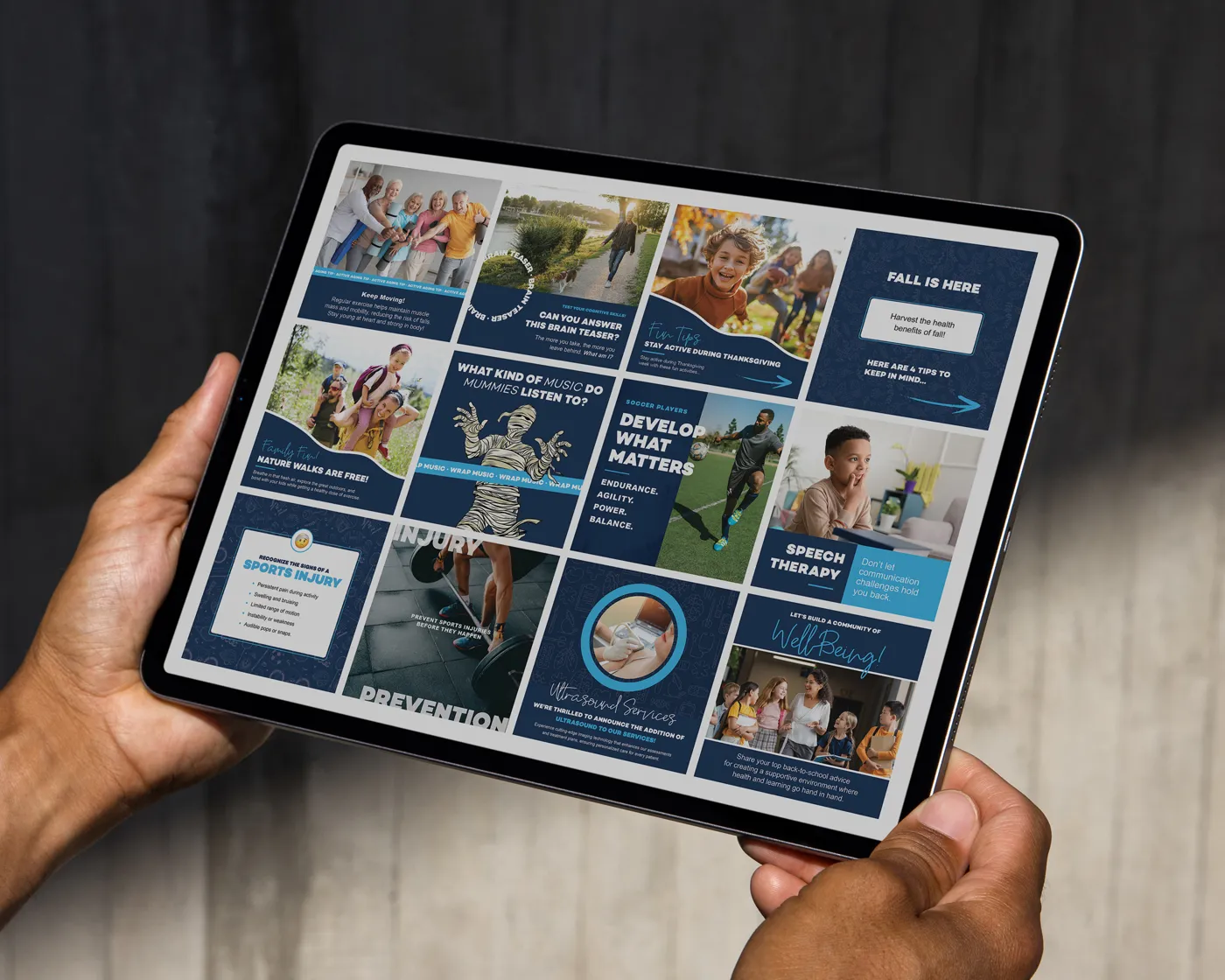 Tablet screen showing a grid of social media posts from Joint Restoration Center. The posts include health tips, community events, lighthearted content like a mummy music joke, information on injury prevention, sports therapy, ultrasound services, and child speech therapy. The design features a navy and blue color scheme with photography and bold typography.